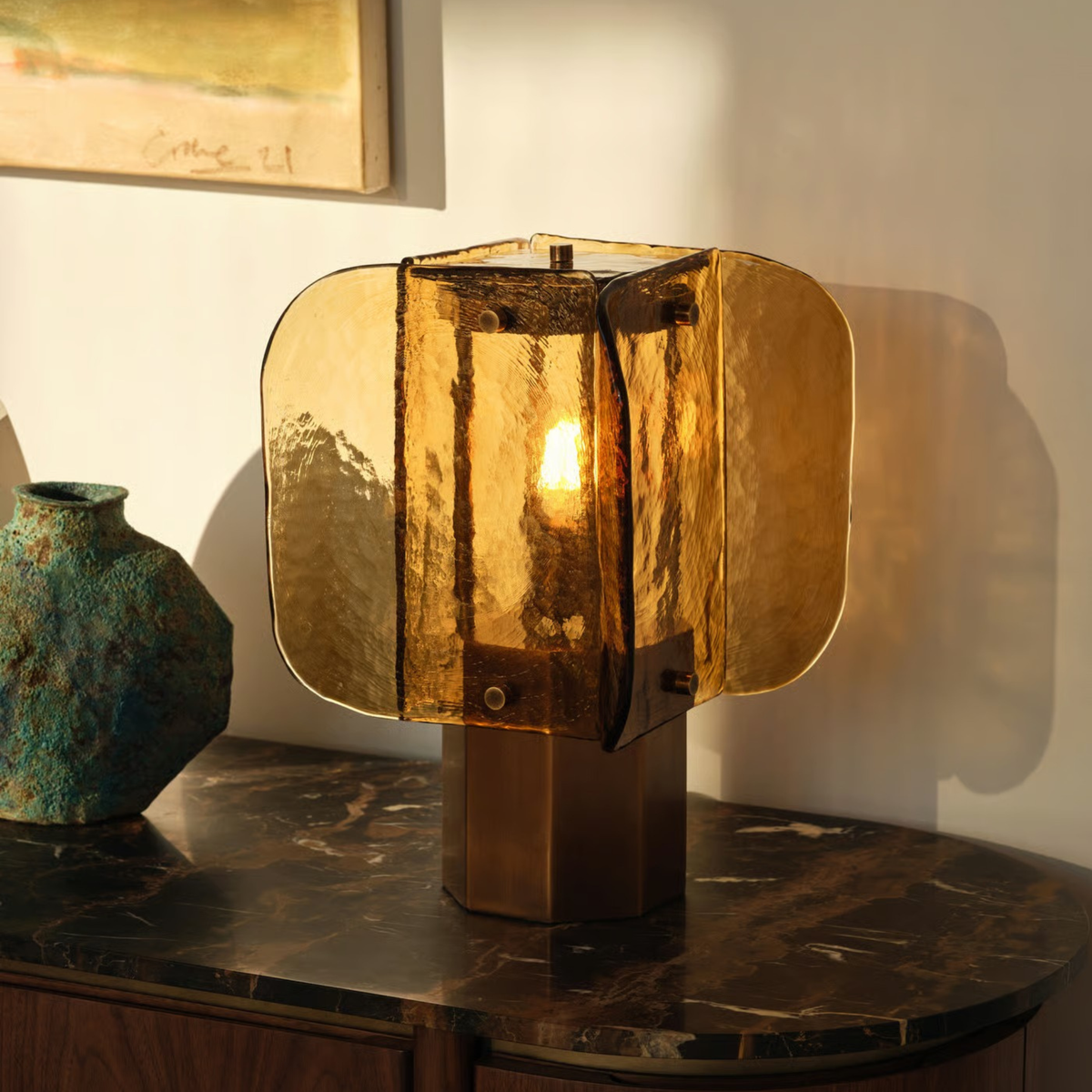 Lámpara de mesa de cristal ámbar Hialina – encendida sobre un aparador