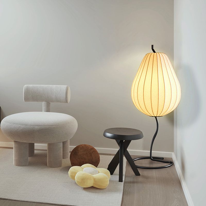 Lámpara de pie en forma de pera con pantalla de tela Fidela junto a un sofá en el salón – imagen 9