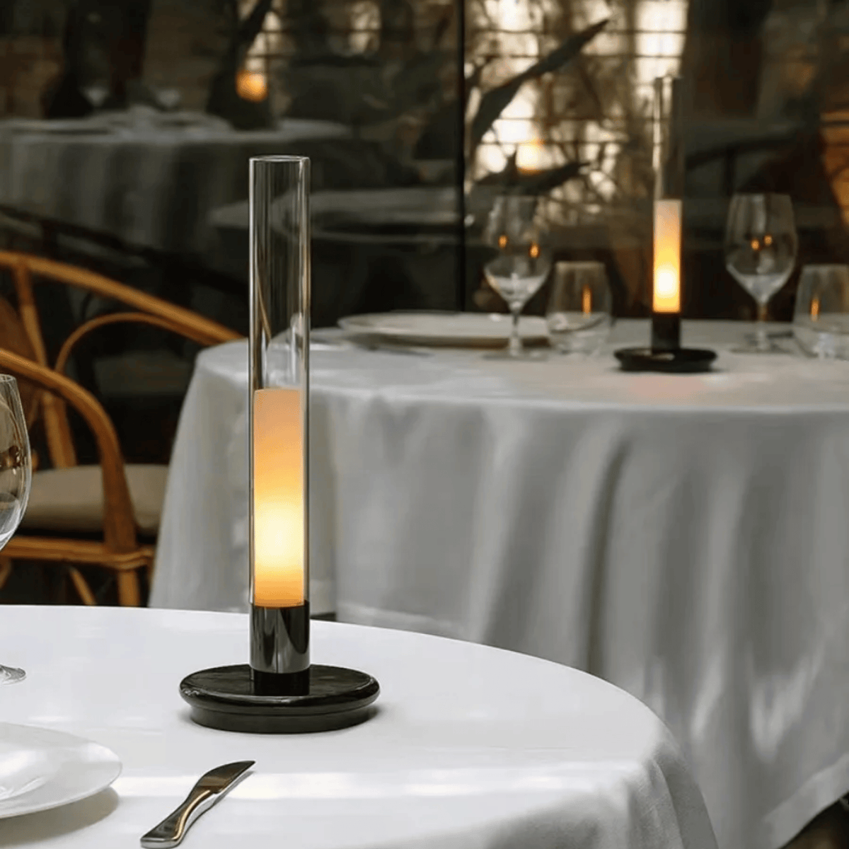 Lámpara de mesa vela recargable Flamela – en una mesa con mantel blanco