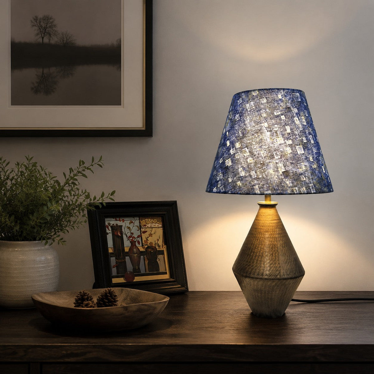 Lámpara de mesa de cerámica Zafiela – encendida junto a cuadros enmarcados
