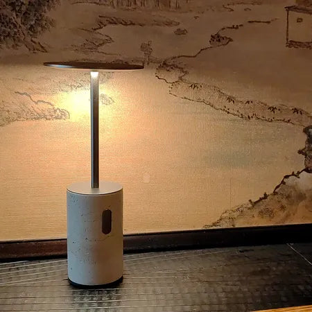 Lámpara de mesa inalámbrica de travertino Tufela – encendida en un ambiente cálido