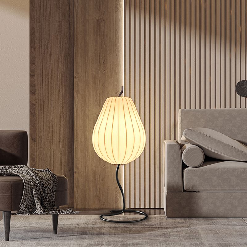 Lámpara de pie en forma de pera con pantalla de tela Fidela junto a un sofá en el salón – imagen 10