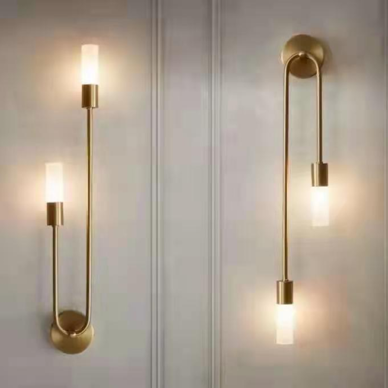 Aplique de pared LED dorado Hilara junto a un cabecero – imagen 4
