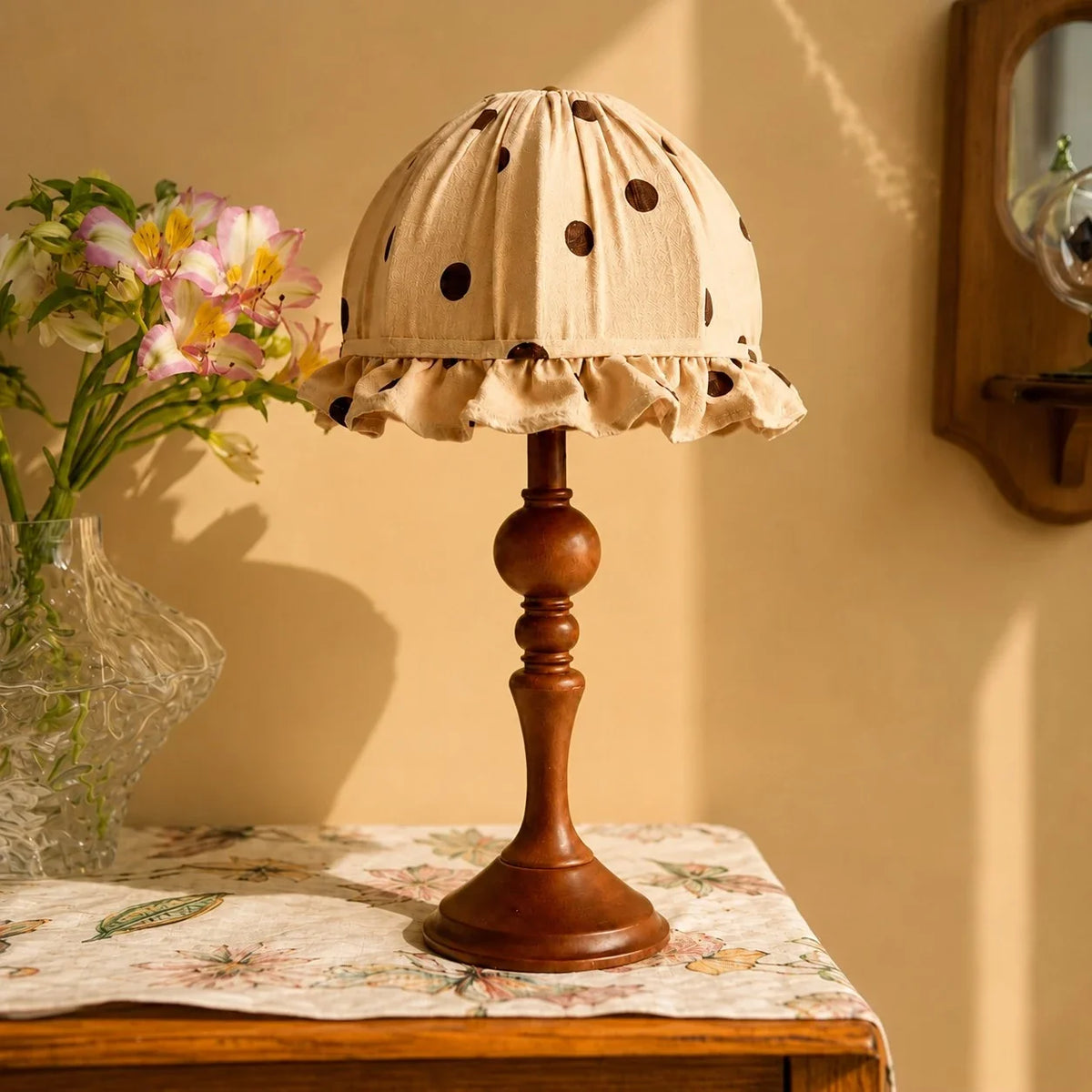 Lámpara de mesa vintage de lunares Topela – sobre una cómoda junto a un jarrón de flores