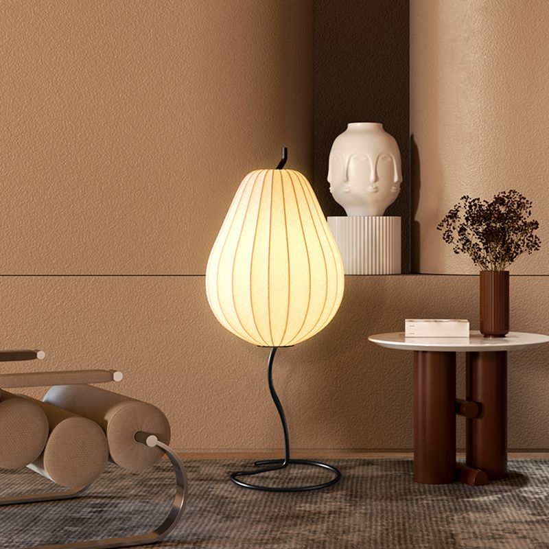 Lámpara de pie en forma de pera con pantalla de tela Fidela junto a un sofá en el salón – imagen 3