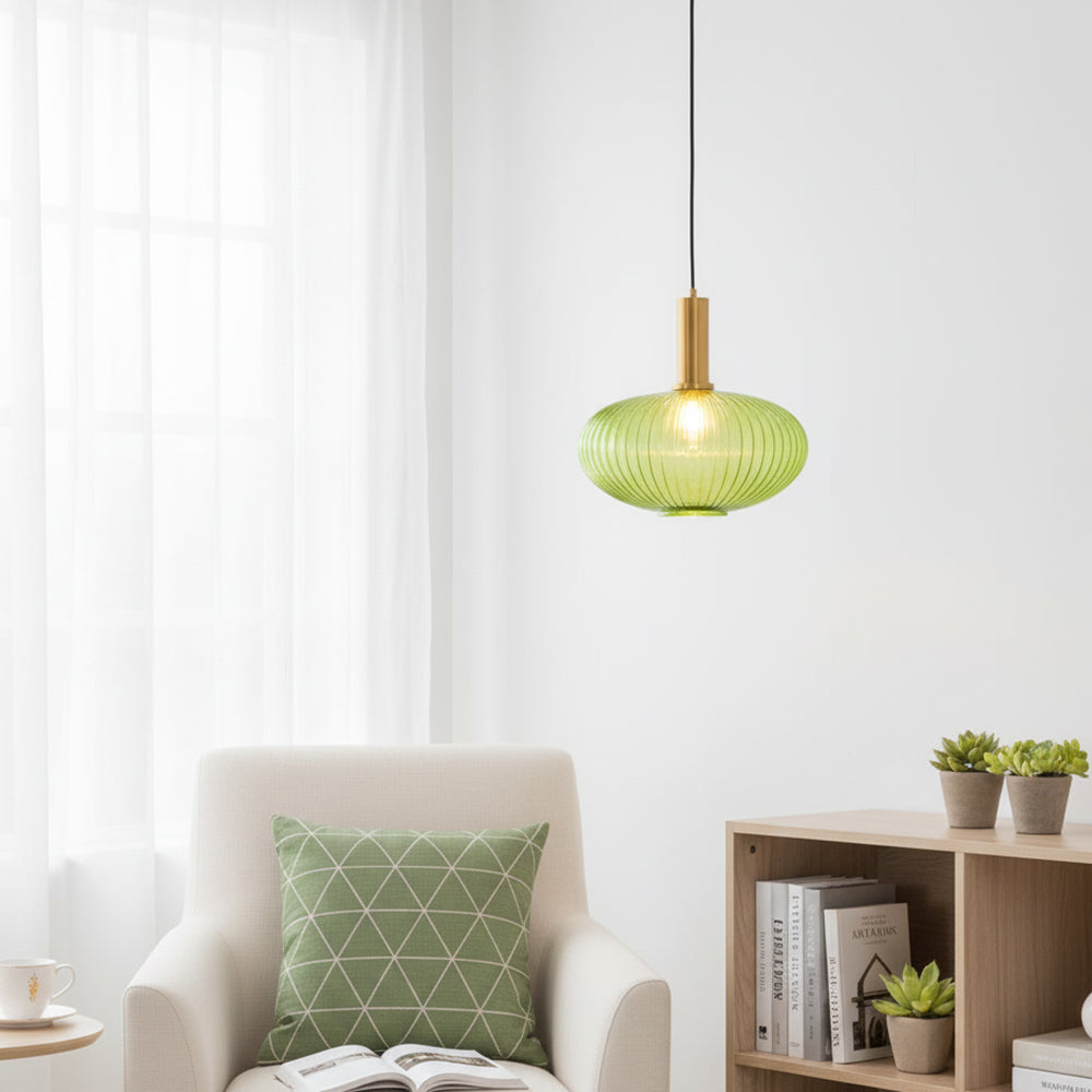 Lámpara colgante de cristal acanalado Acanela – en verde junto a un sillón
