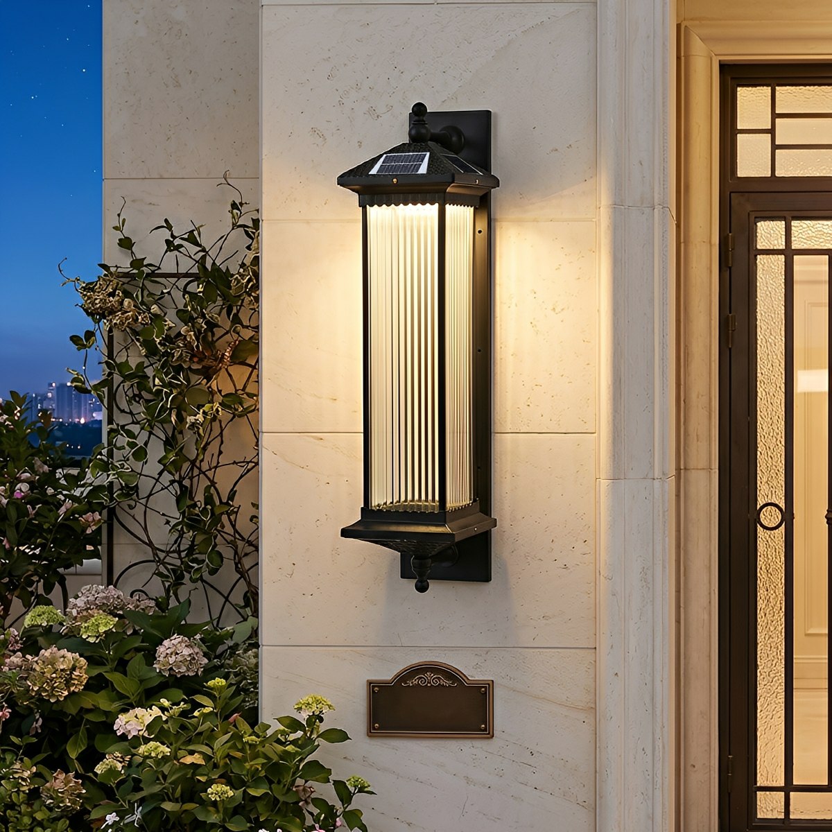 Farol solar de pared exterior Iorena – encendido junto a una puerta