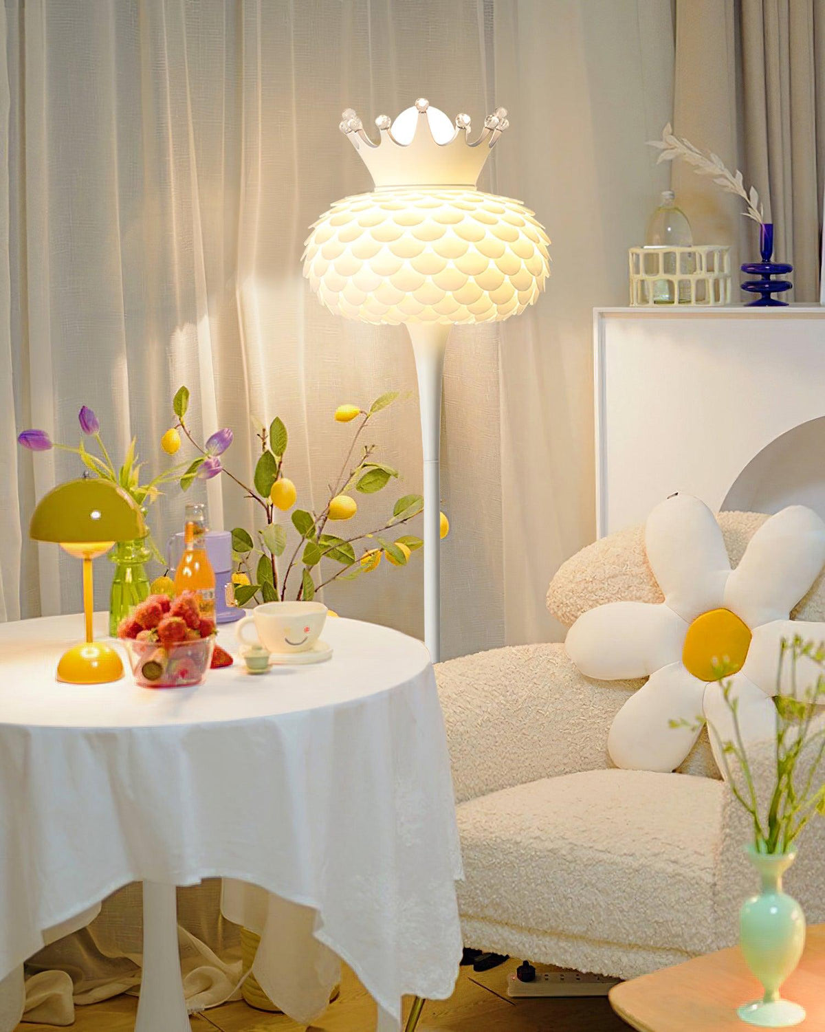 Lámpara de pie blanca con corona y pantalla texturizada Halvira – junto a una mesa redonda con flores