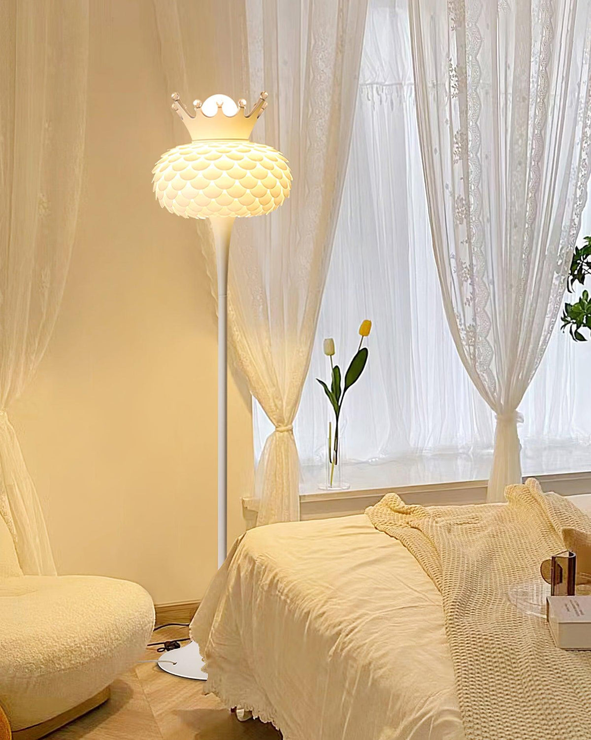 Lámpara de pie blanca con corona y pantalla texturizada Halvira – junto a un sofá y unas cortinas claras