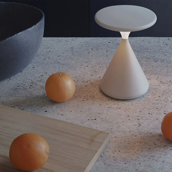 Lámpara de mesa recargable Relina – en blanco sobre una mesa de piedra