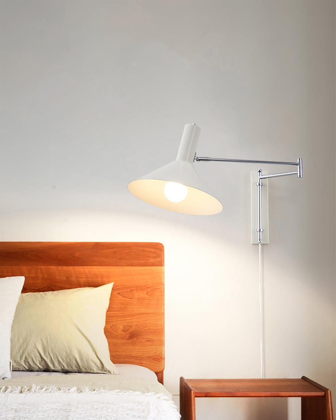 Aplique de pared articulado Brazola junto a un sillón de lectura – imagen 8