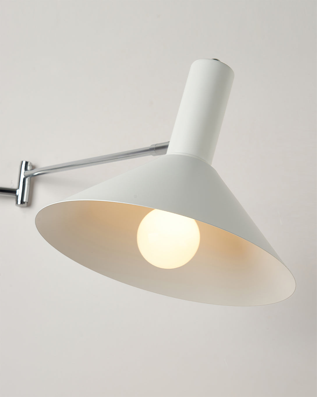 Aplique de pared articulado Brazola junto a un sillón de lectura – imagen 16