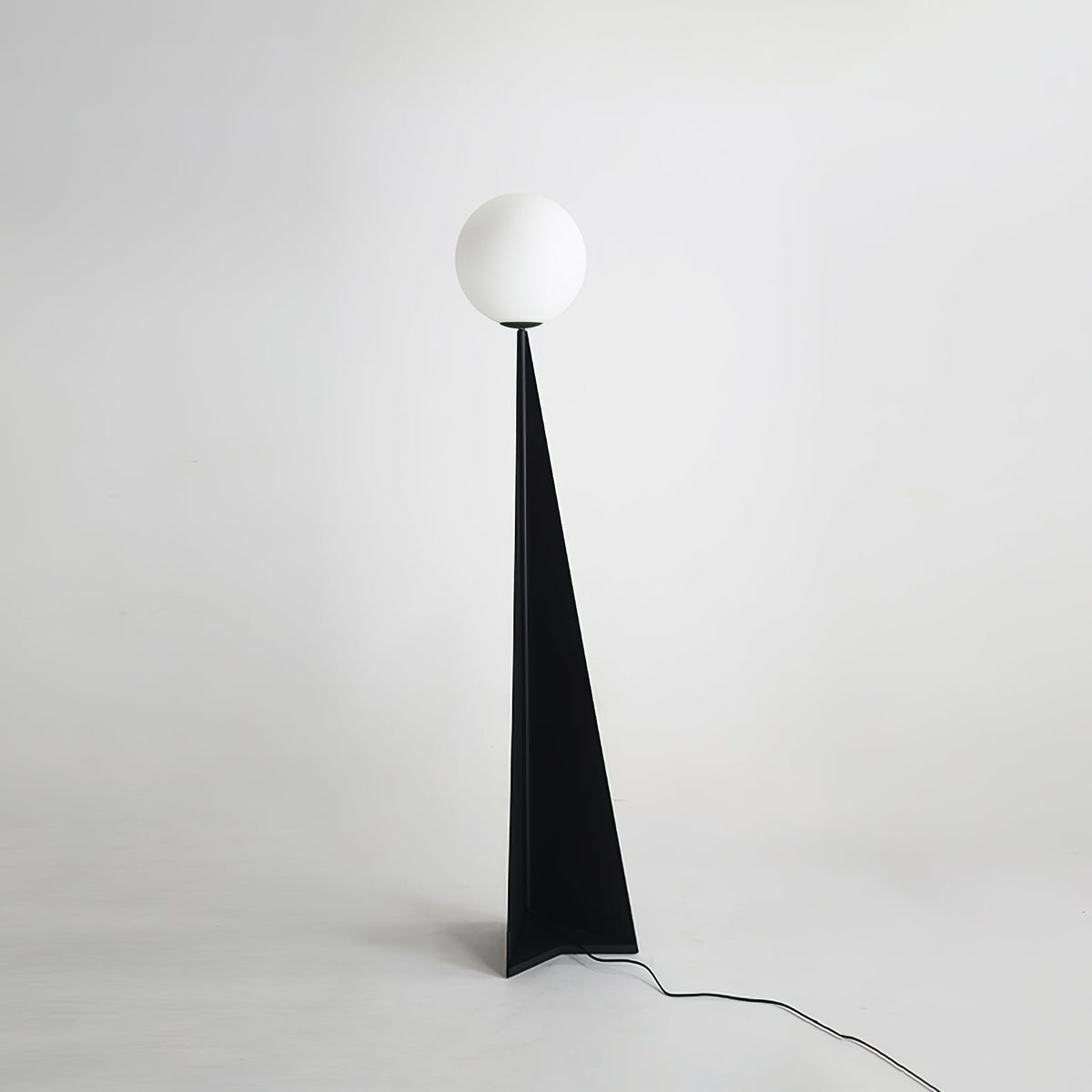 Lámpara de pie con esfera blanca y base triangular negra Pelia – vista completa sobre fondo gris claro
