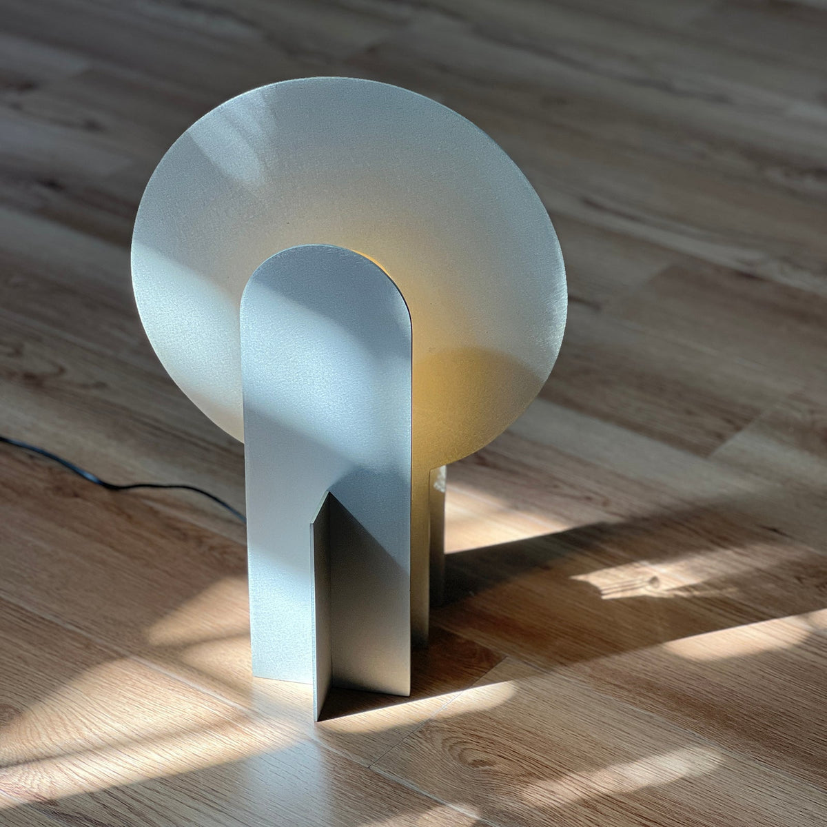 Lámpara de mesa de acero con arco Mardela sobre un aparador moderno – imagen 7