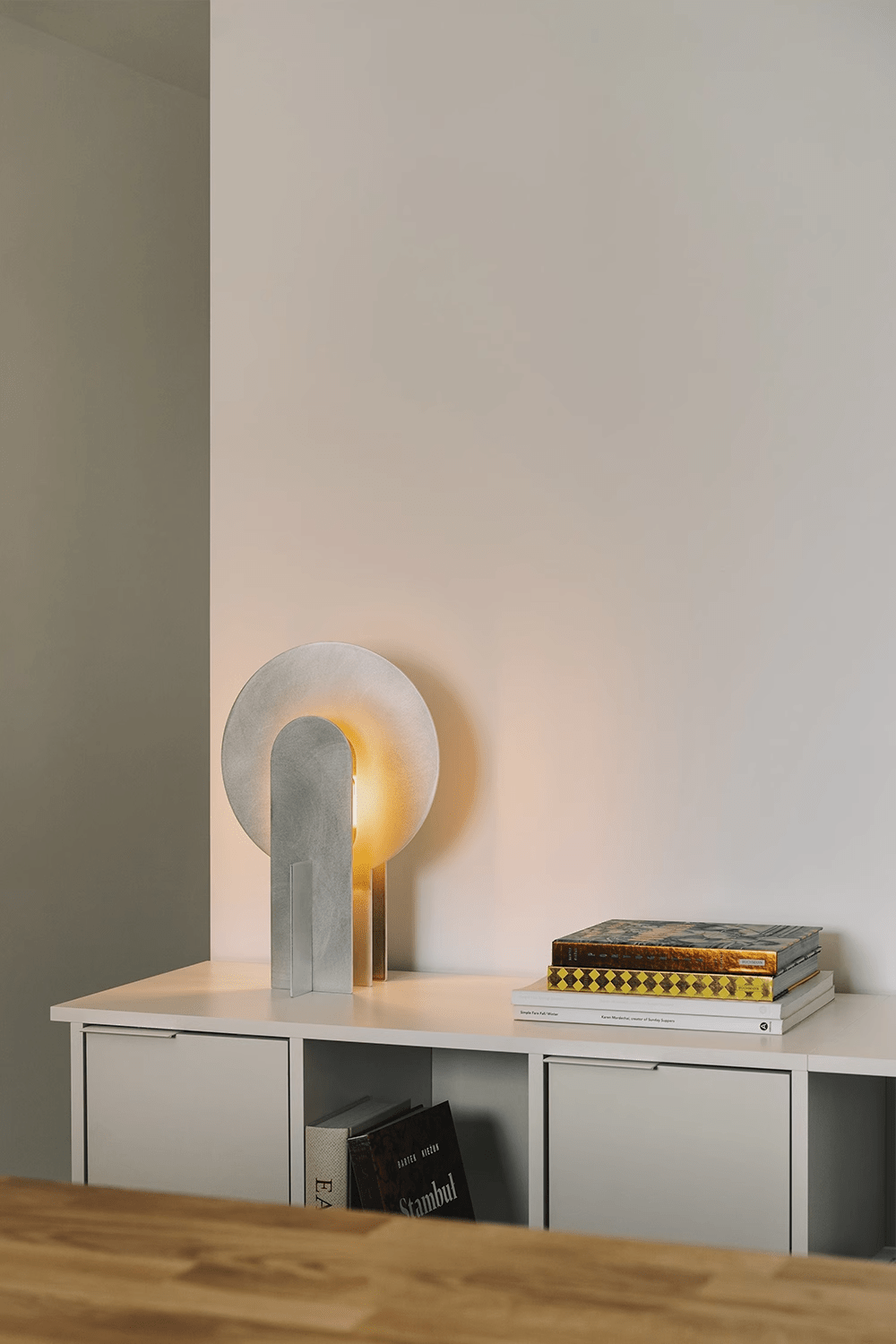 Lámpara de mesa de acero con arco Mardela sobre un aparador moderno – imagen 10