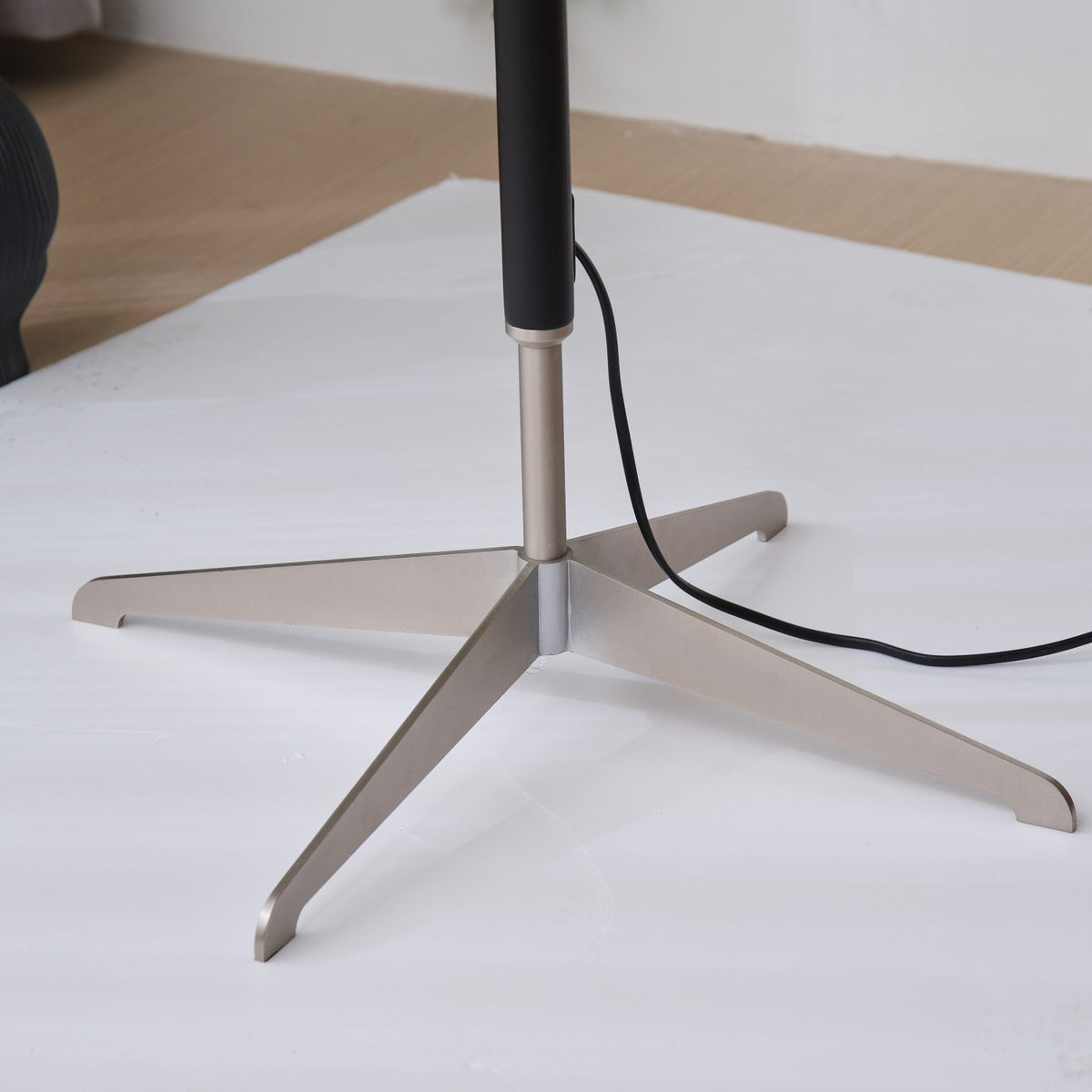 Lámpara de pie con base trípode y pantalla de tela blanca Iluma – detalle de la base de tres patas sobre fondo blanco