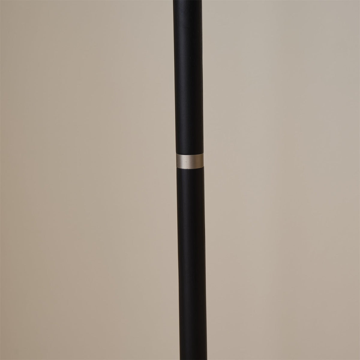 Lámpara de pie con base trípode y pantalla de tela blanca Iluma – detalle de la columna negra con anillo metálico