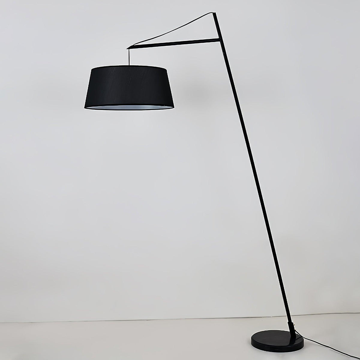 Lámpara de pie de arco negra con pantalla de tela Bruvena junto a un sofá en el salón – imagen 4