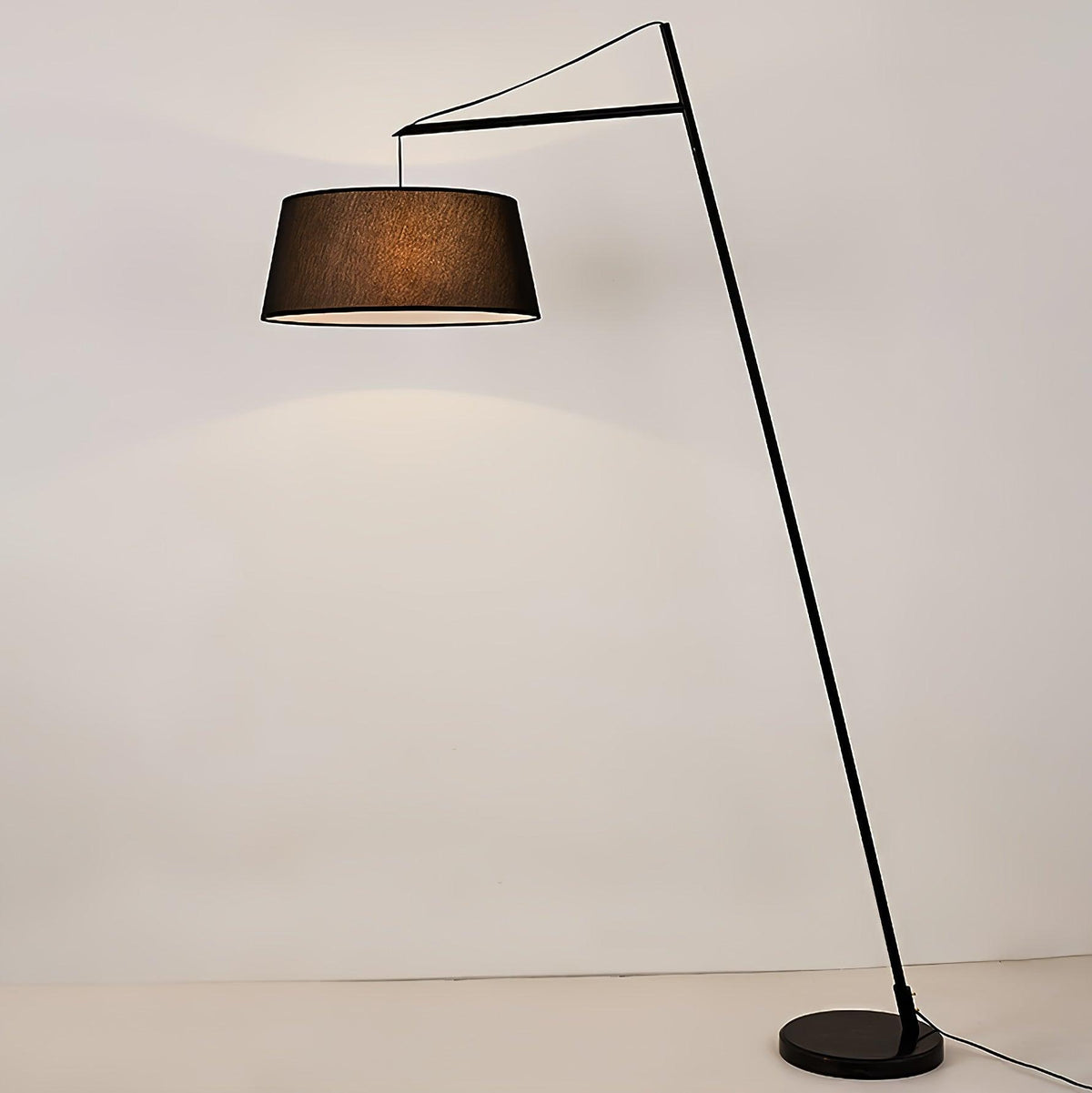 Lámpara de pie de arco negra con pantalla de tela Bruvena junto a un sofá en el salón – imagen 5