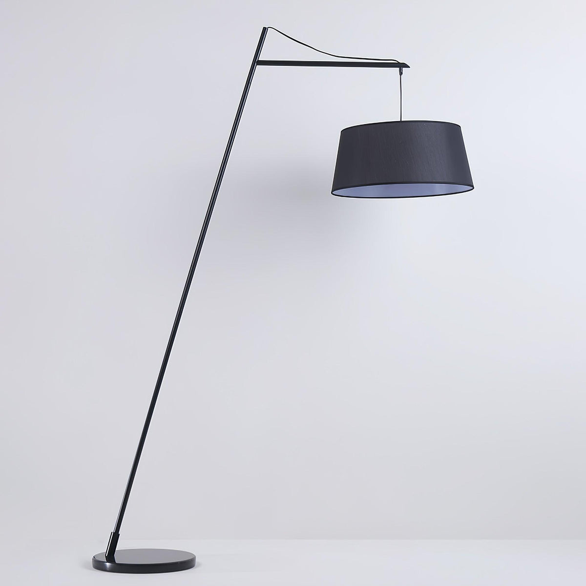 Lámpara de pie de arco negra con pantalla de tela Bruvena junto a un sofá en el salón – imagen 9