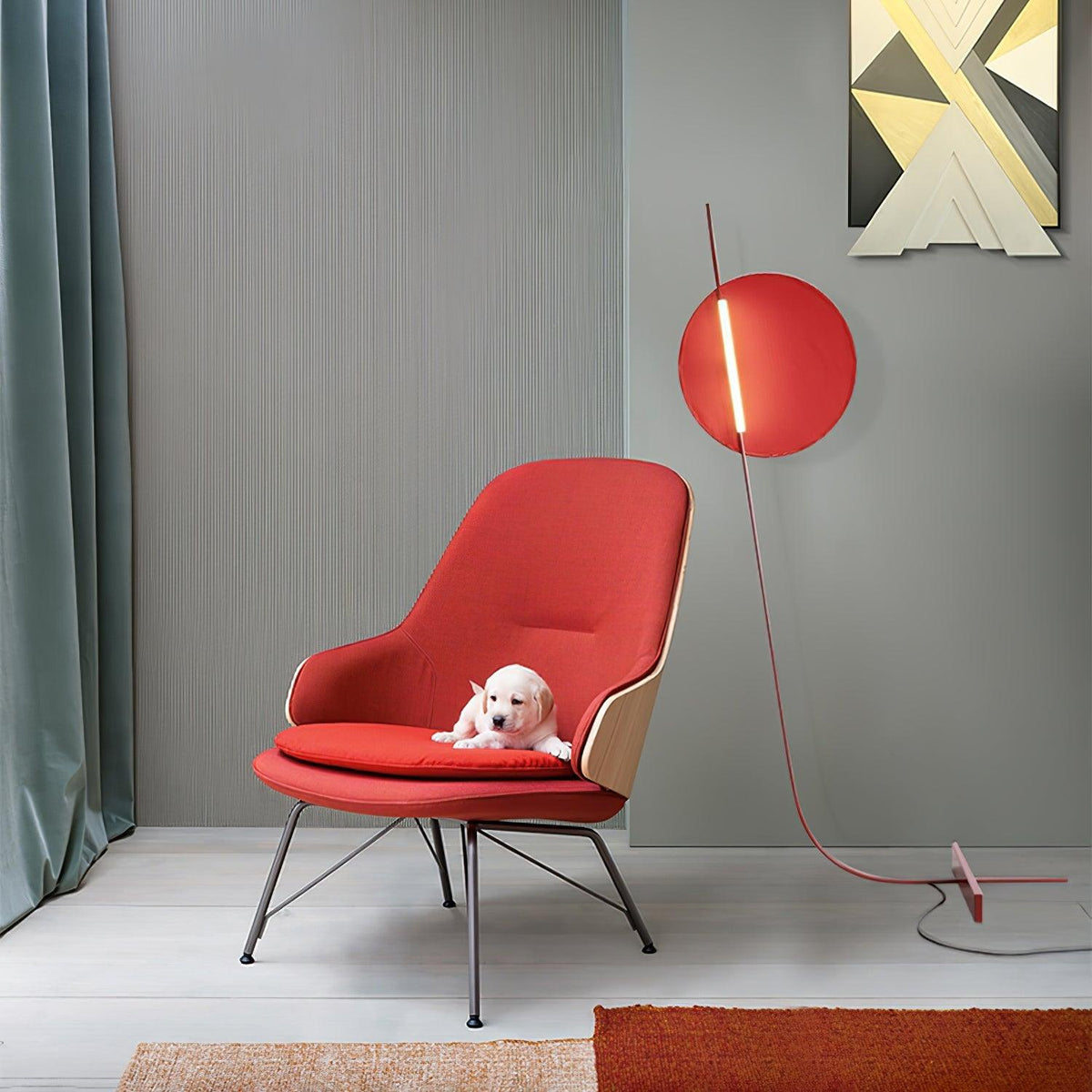 Lámpara de pie LED roja con disco de luz y varilla curva Oriola – junto a un sillón rojo