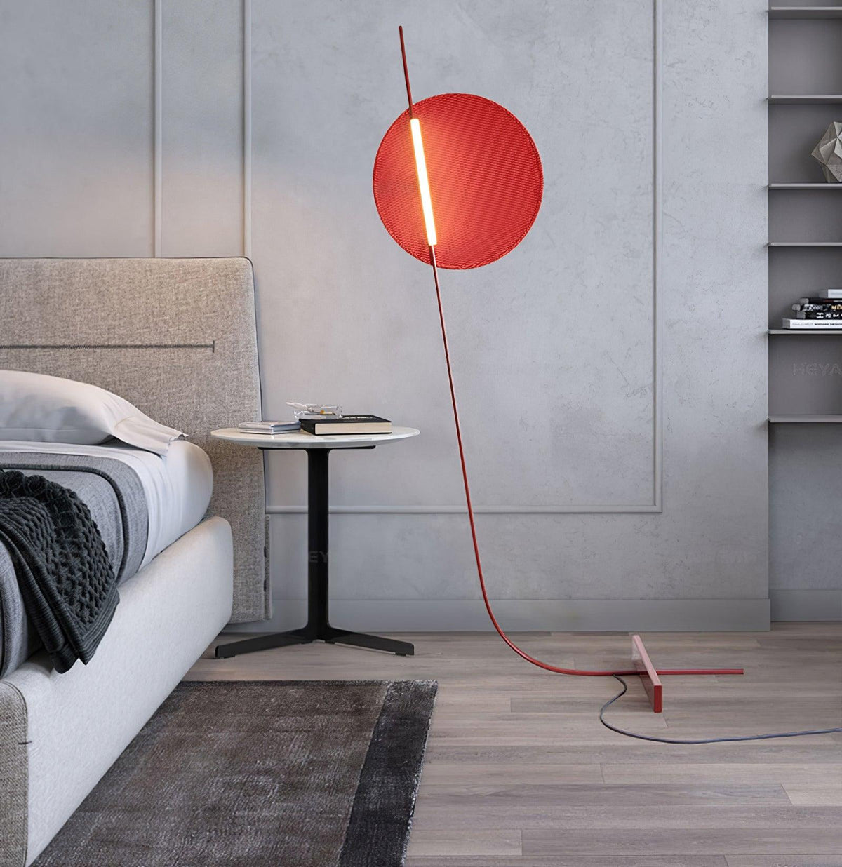 Lámpara de pie LED roja con disco de luz y varilla curva Oriola – junto a una cama con ropa gris