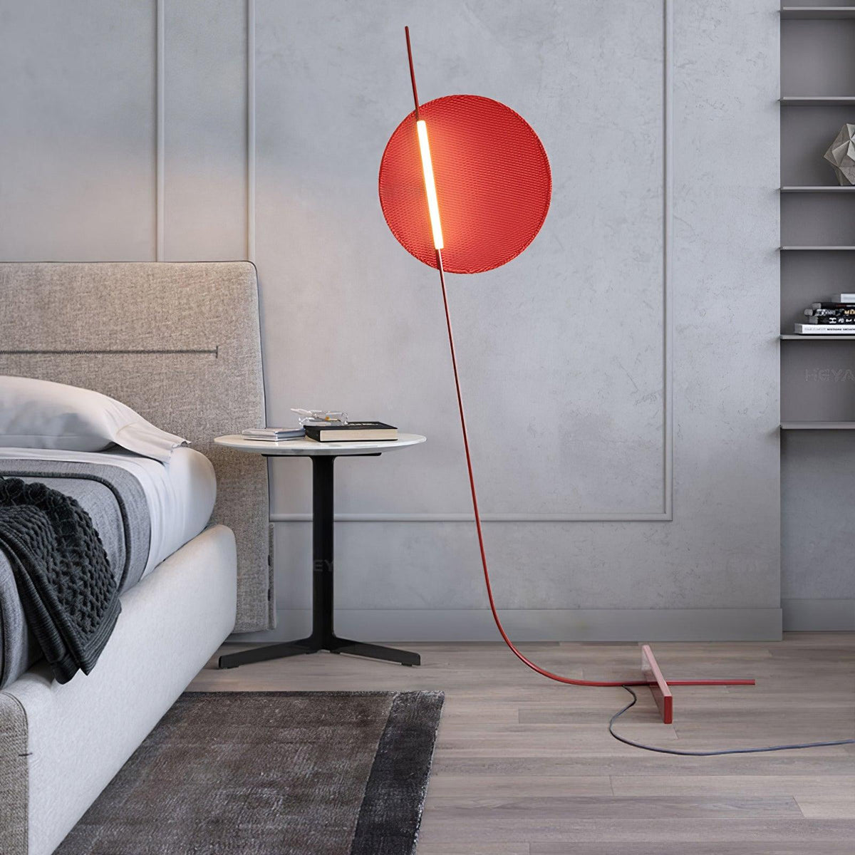 Lámpara de pie LED roja con disco de luz y varilla curva Oriola – junto a una cama con mesita redonda
