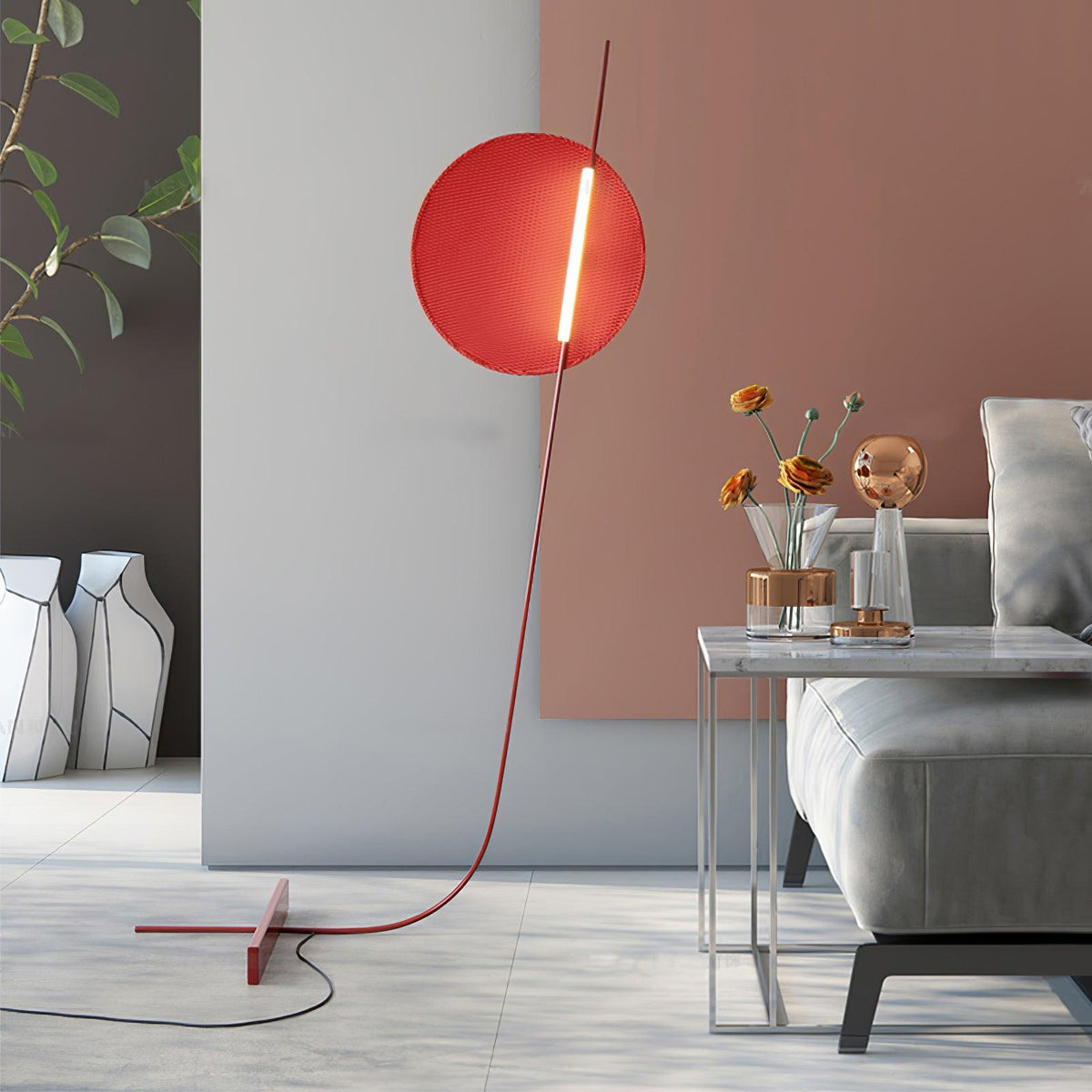 Lámpara de pie LED roja con disco de luz y varilla curva Oriola – junto a un sofá y un jarrón