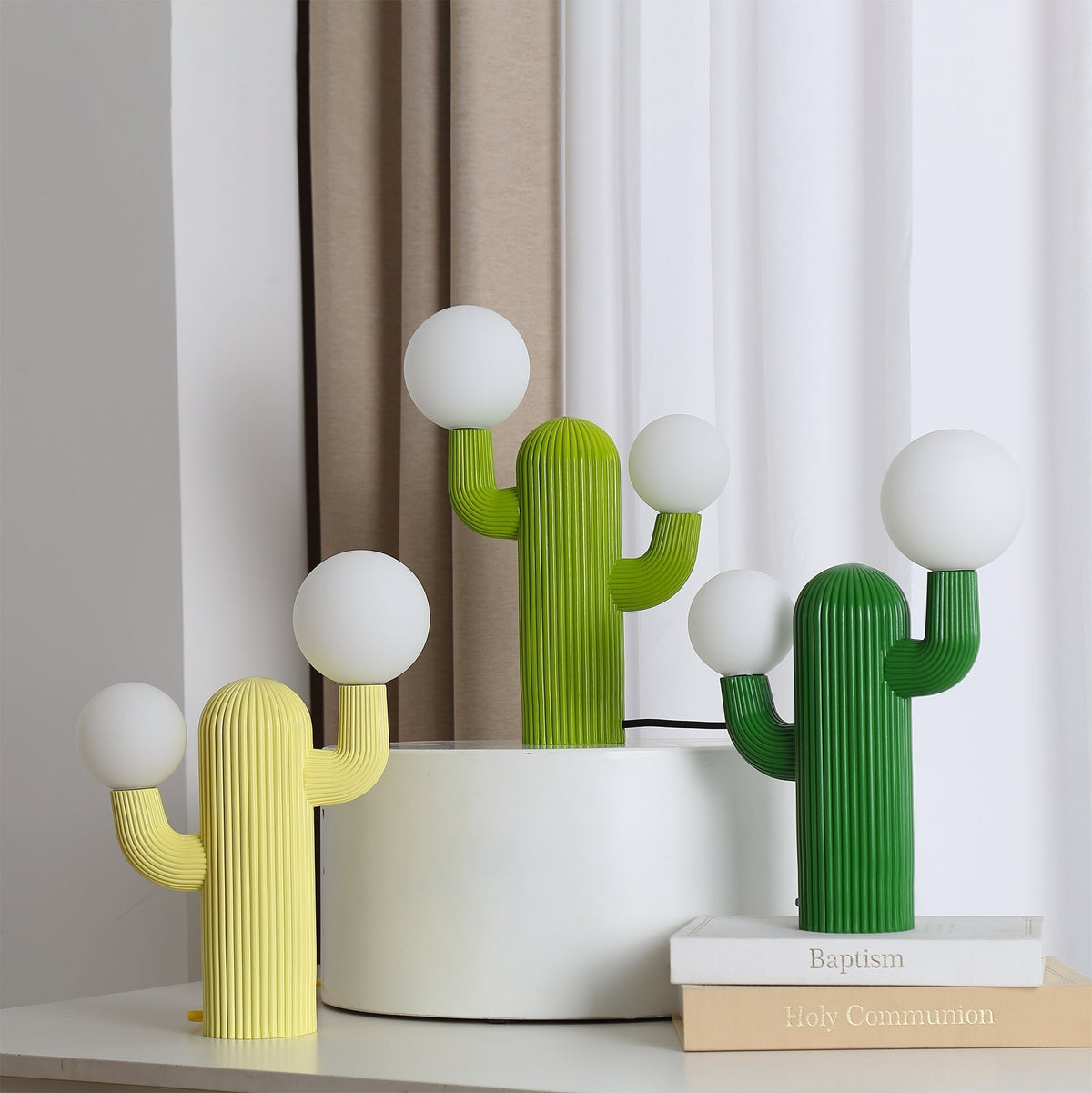 Lámpara de mesa cactus Saguaro – en verde claro, amarillo y verde junto a una ventana