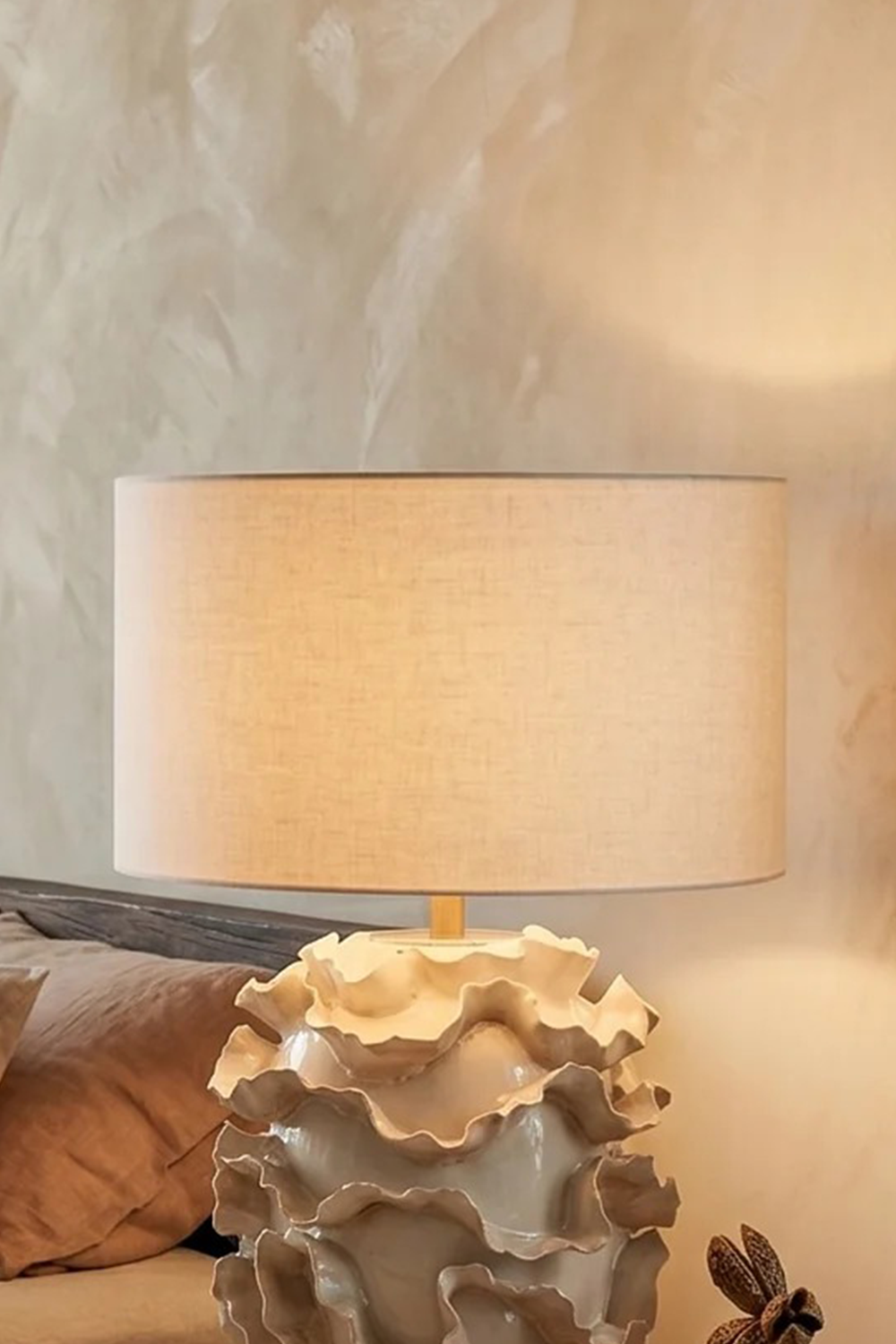 Lámpara de mesa de cerámica Volera – encendida junto a un sofá