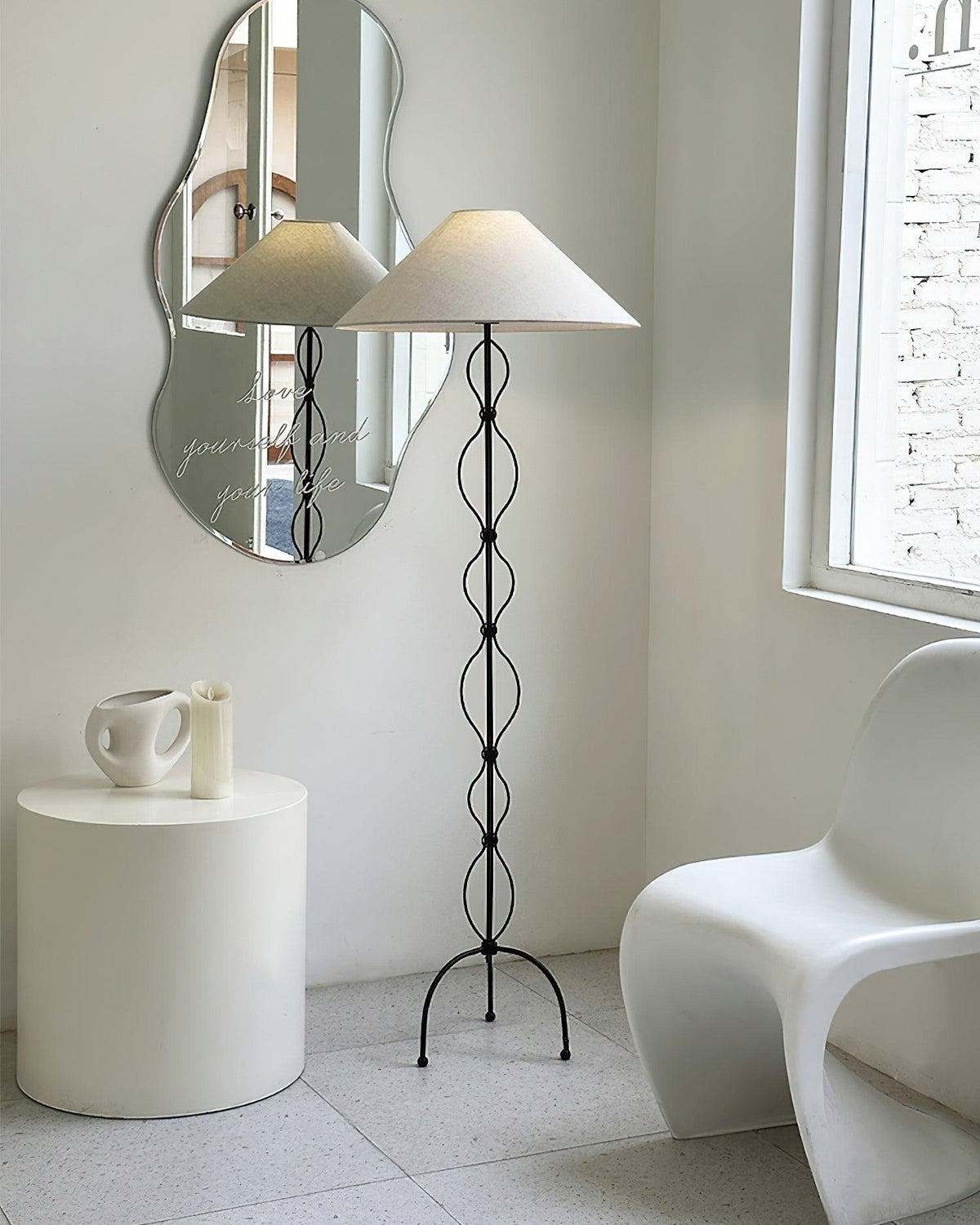 Lámpara de pie de hierro forjado Rizalia – junto a una silla blanca