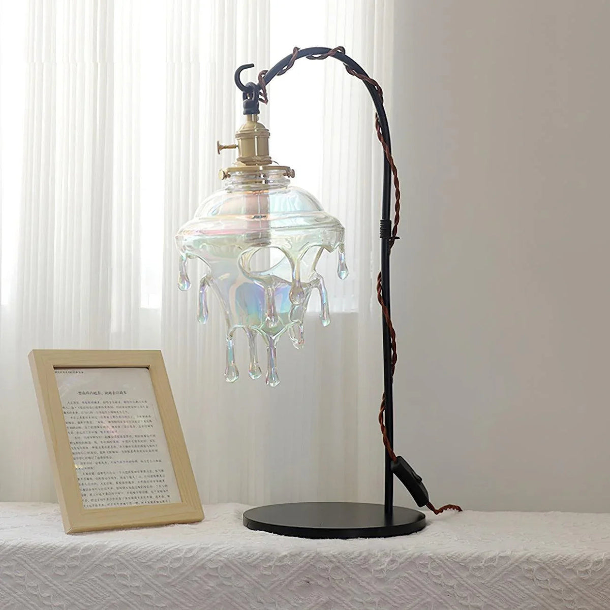 Lámpara de mesa de cristal Rociela – con cristal transparente junto a un marco
