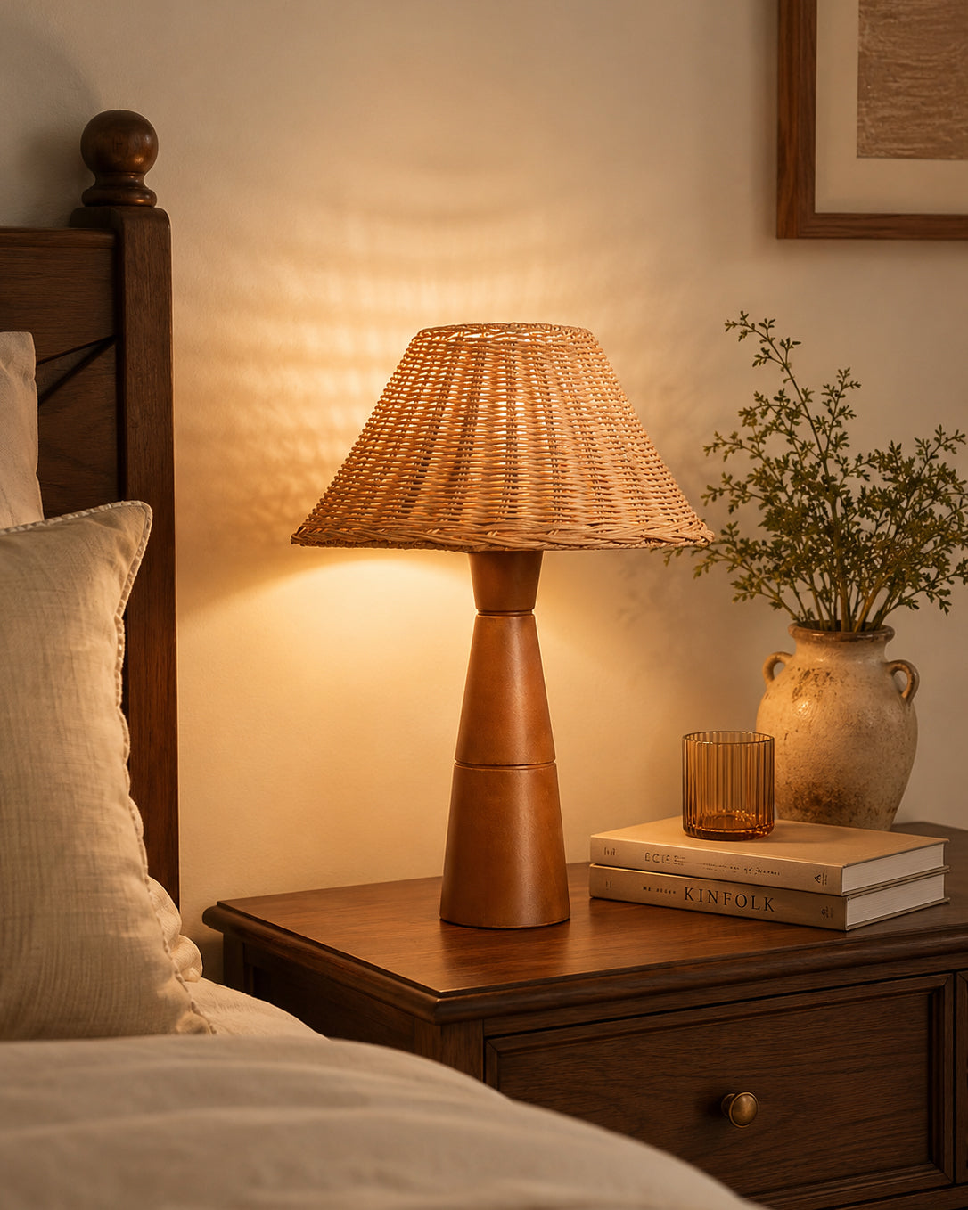 Lámpara de mesa de ratán con base de madera Ratena – encendida junto a la cama