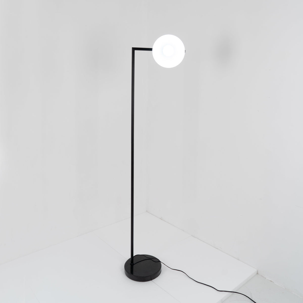 Lámpara de pie con difusor cónico Quenora – encendida con luz indirecta