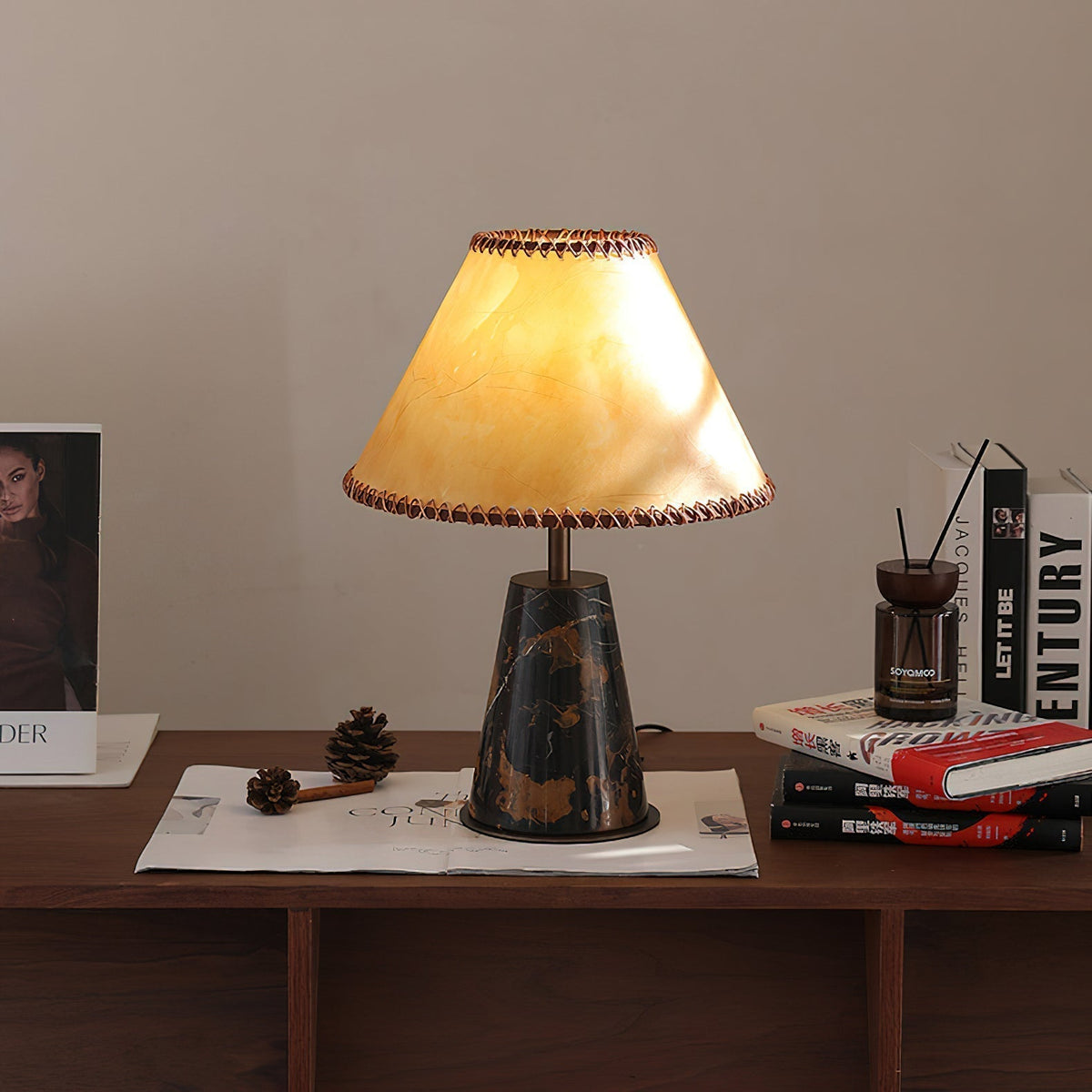Lámpara de mesa de mármol Rustana – sobre una cómoda junto a libros