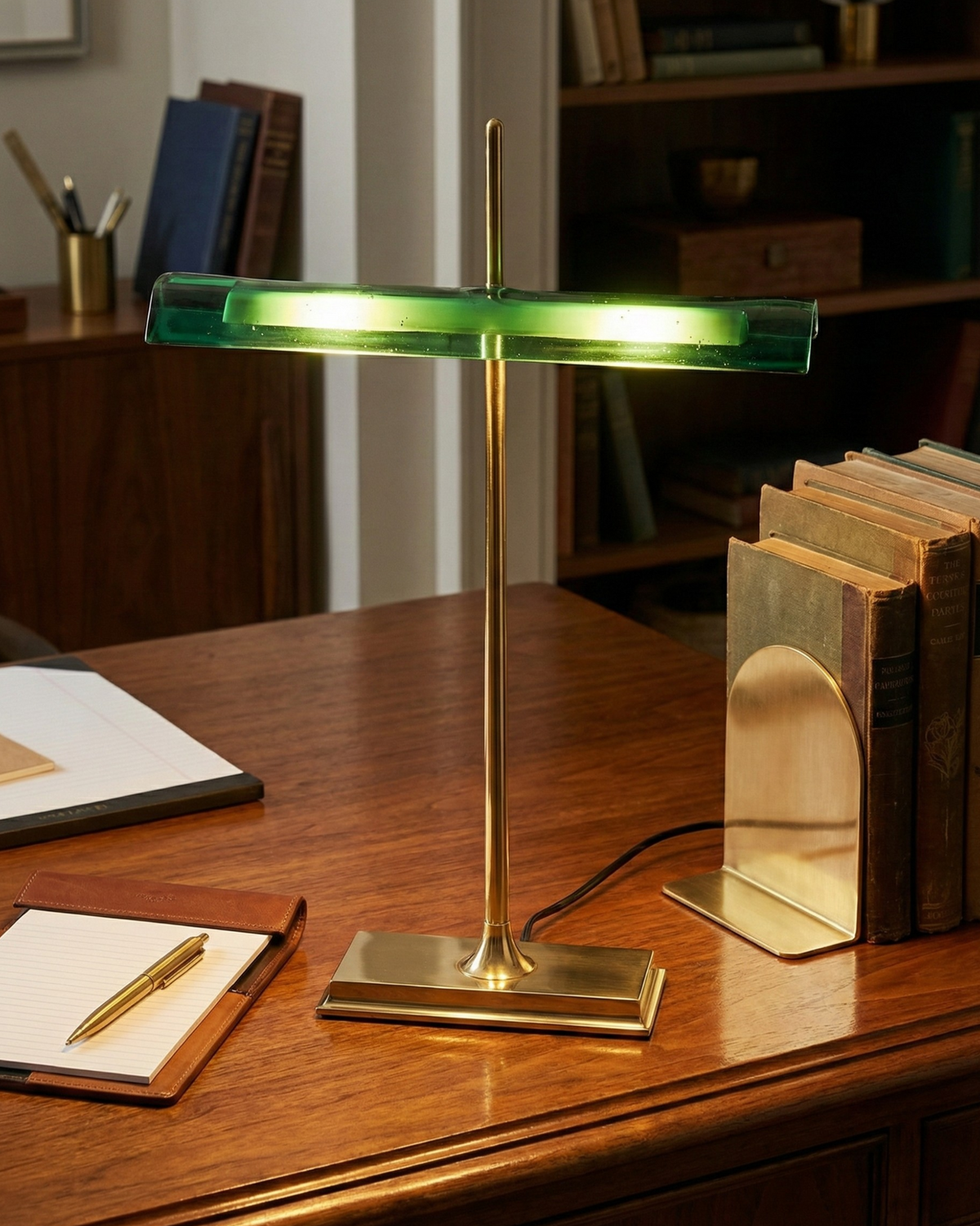 Lámpara de escritorio LED Kalema – encendida sobre un escritorio de madera