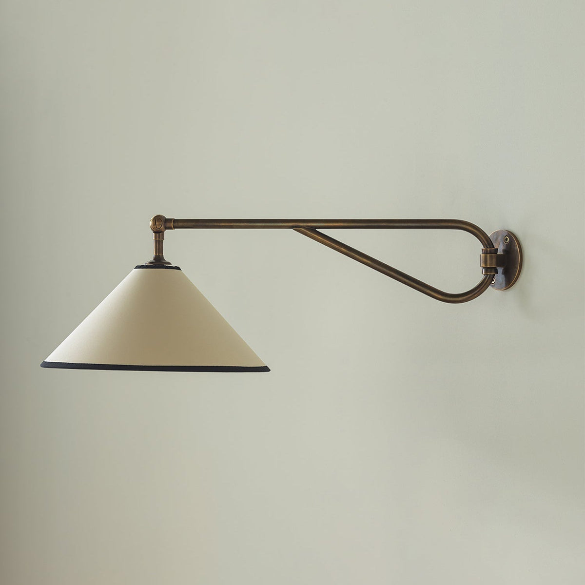 Aplique de pared con brazo giratorio Jalvira – brazo extendido sobre una pared verde