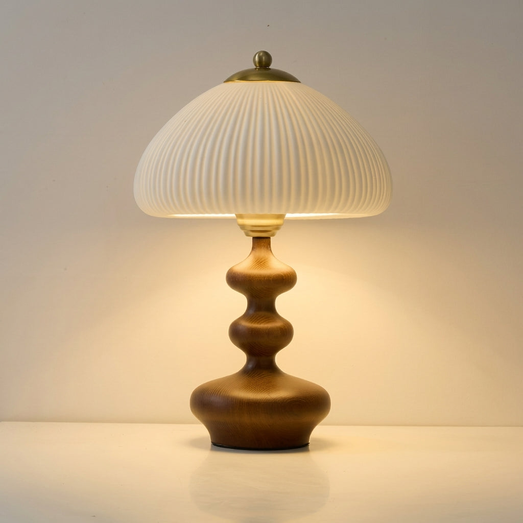 Lámpara de mesa de madera torneada Ruecola – encendida con luz cálida en nogal