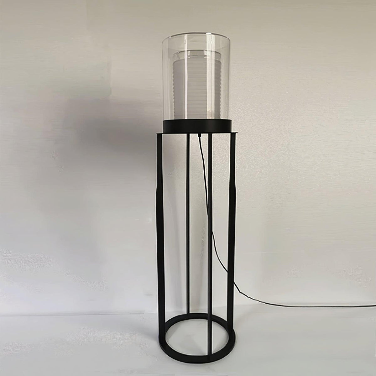 Lámpara de pie LED de doble cilindro de vidrio y estructura negra Navira – sobre fondo neutro con suelo claro