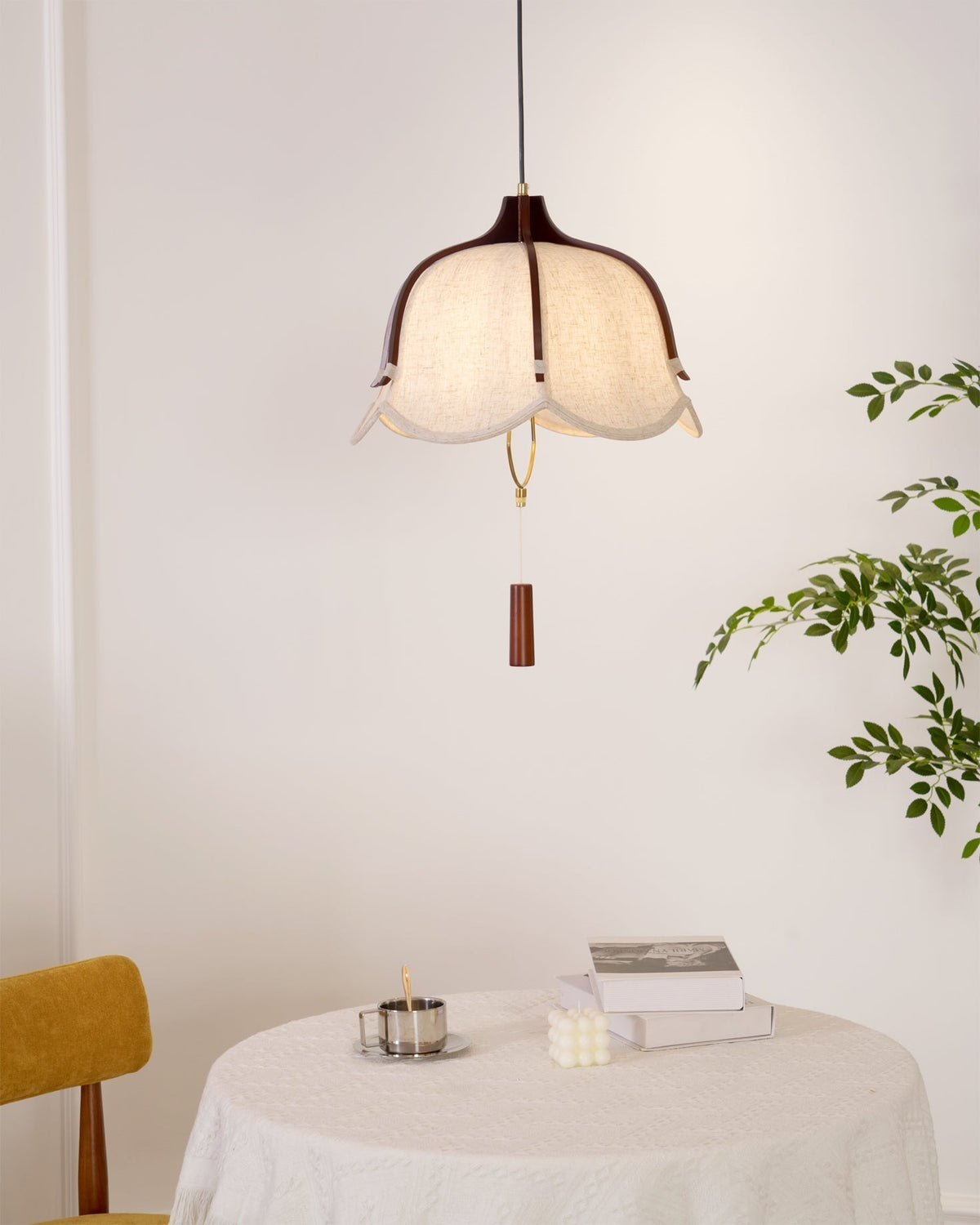Lámpara colgante de tela y madera Floriela sobre una mesa de comedor – imagen 9