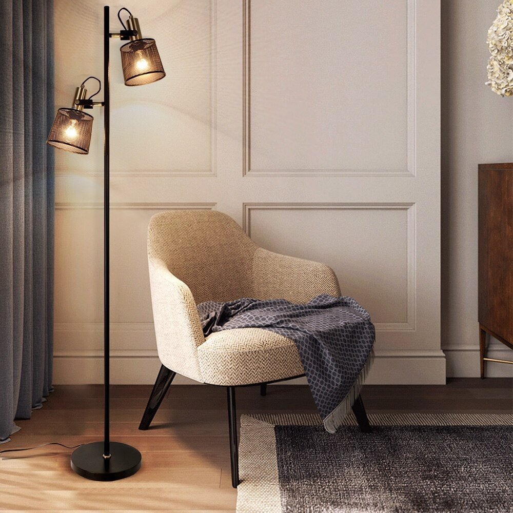 Lámpara de pie de dos focos Ramira – junto a un sillón