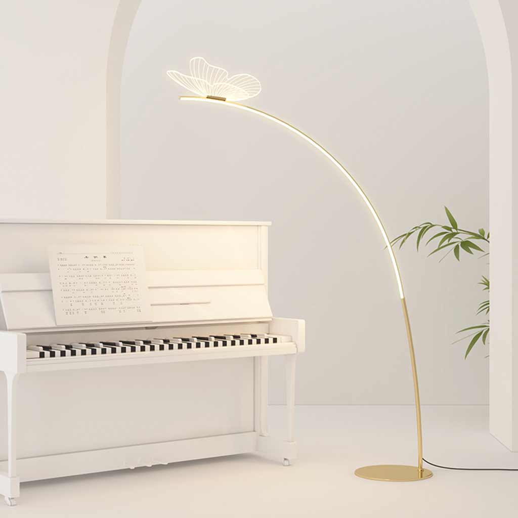 Lámpara de pie de arco con mariposa Sualeta – junto a un piano