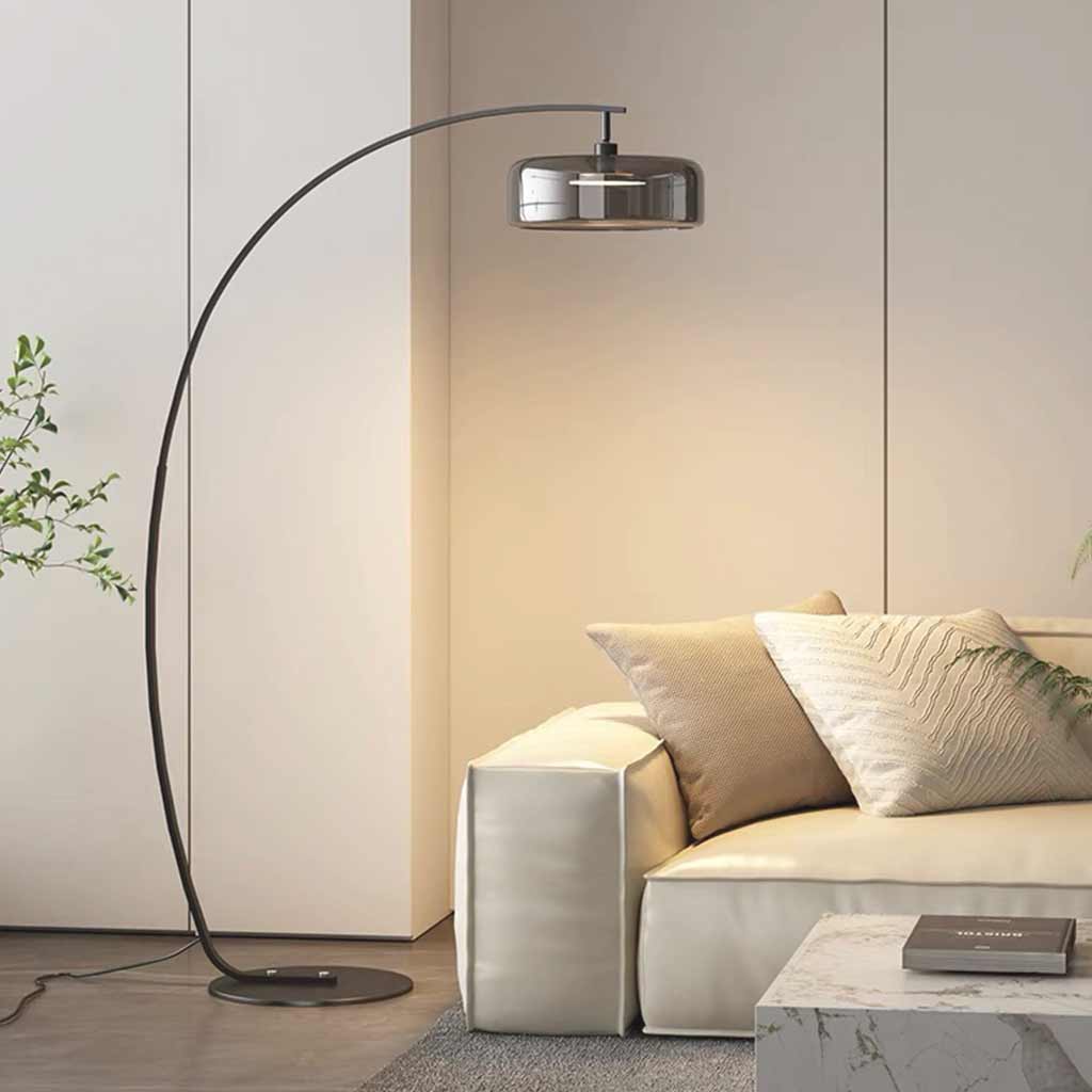 Lámpara de pie de arco Varmela – gris ahumado junto al sofá