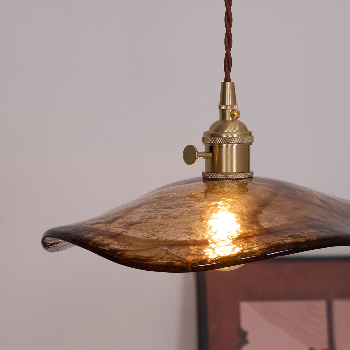 Lámpara colgante de cristal ámbar Ambreta – pantalla de cristal y latón encendida