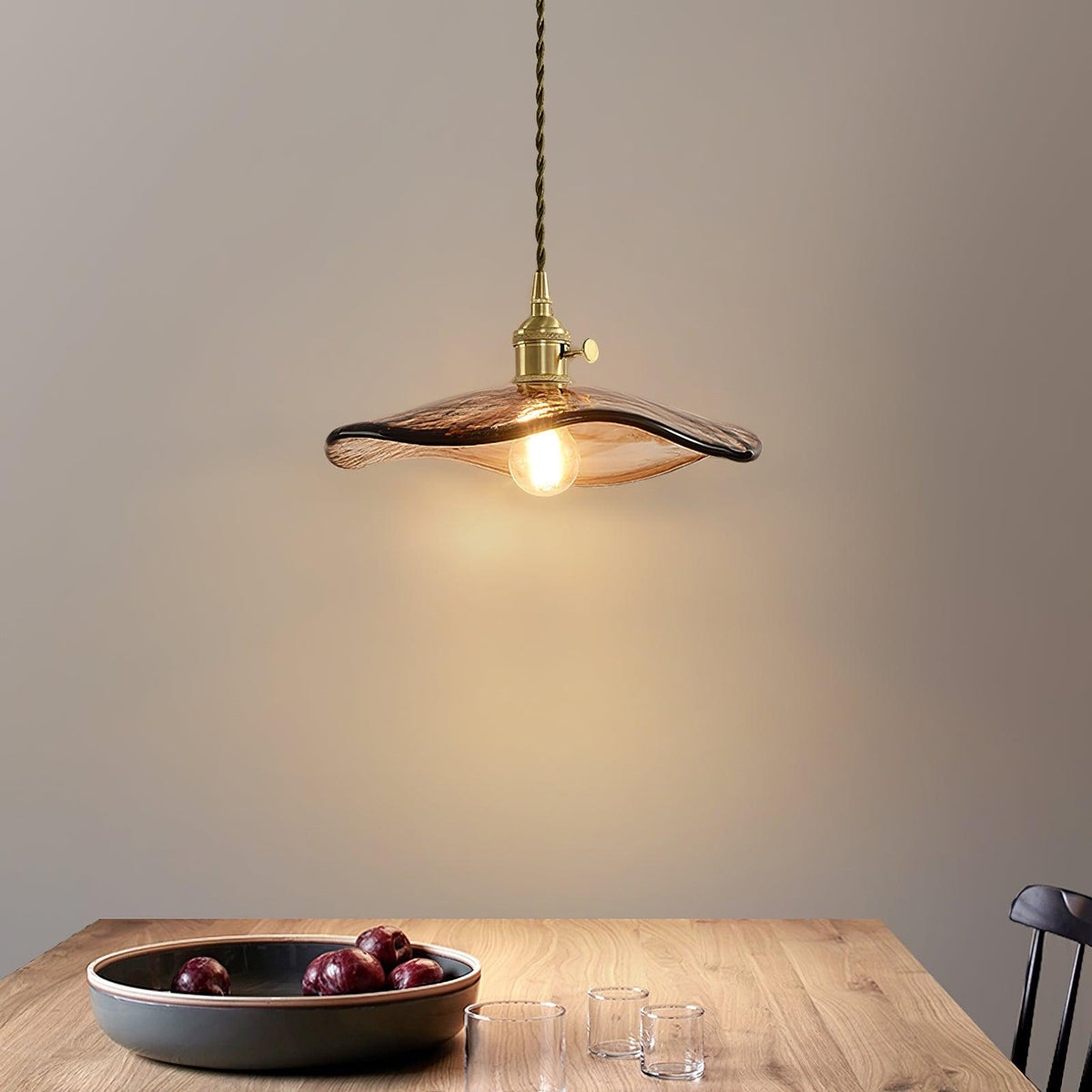 Lámpara colgante de cristal ámbar Ambreta – sobre una mesa de madera
