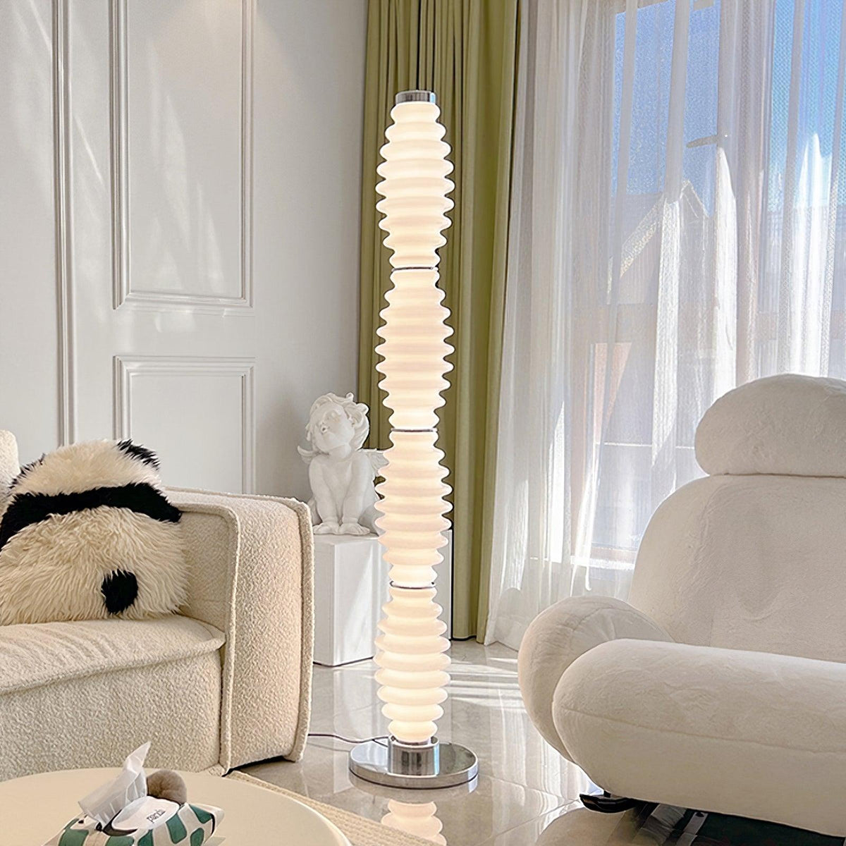 Lámpara de pie de cristal Tulara – junto a un sofá crema y una butaca