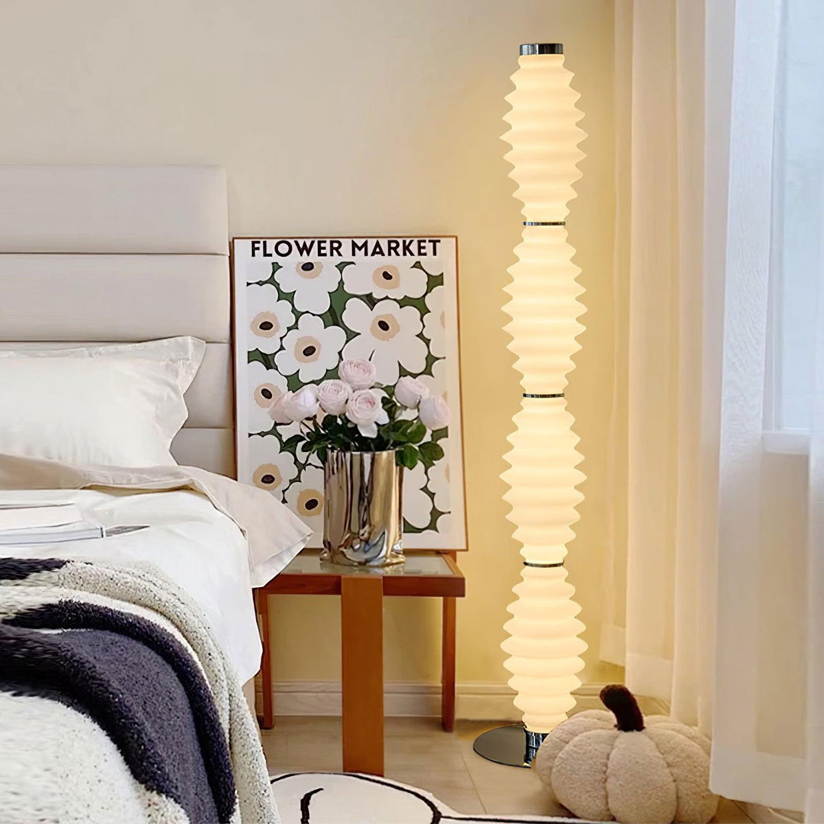Lámpara de pie de cristal Tulara – junto a una cama y una mesita