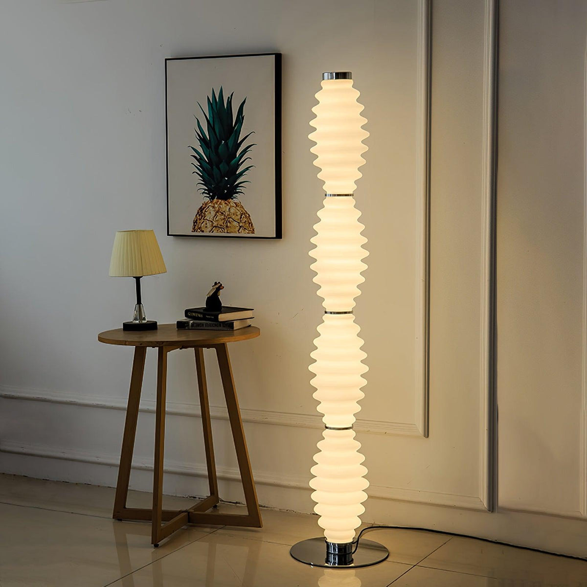 Lámpara de pie de cristal Tulara – junto a una mesa auxiliar de madera