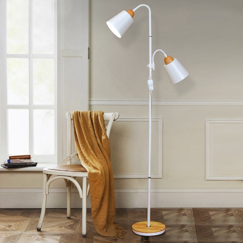 Lámpara de pie nórdica de dos focos Ramita – en blanco junto a una silla con manta