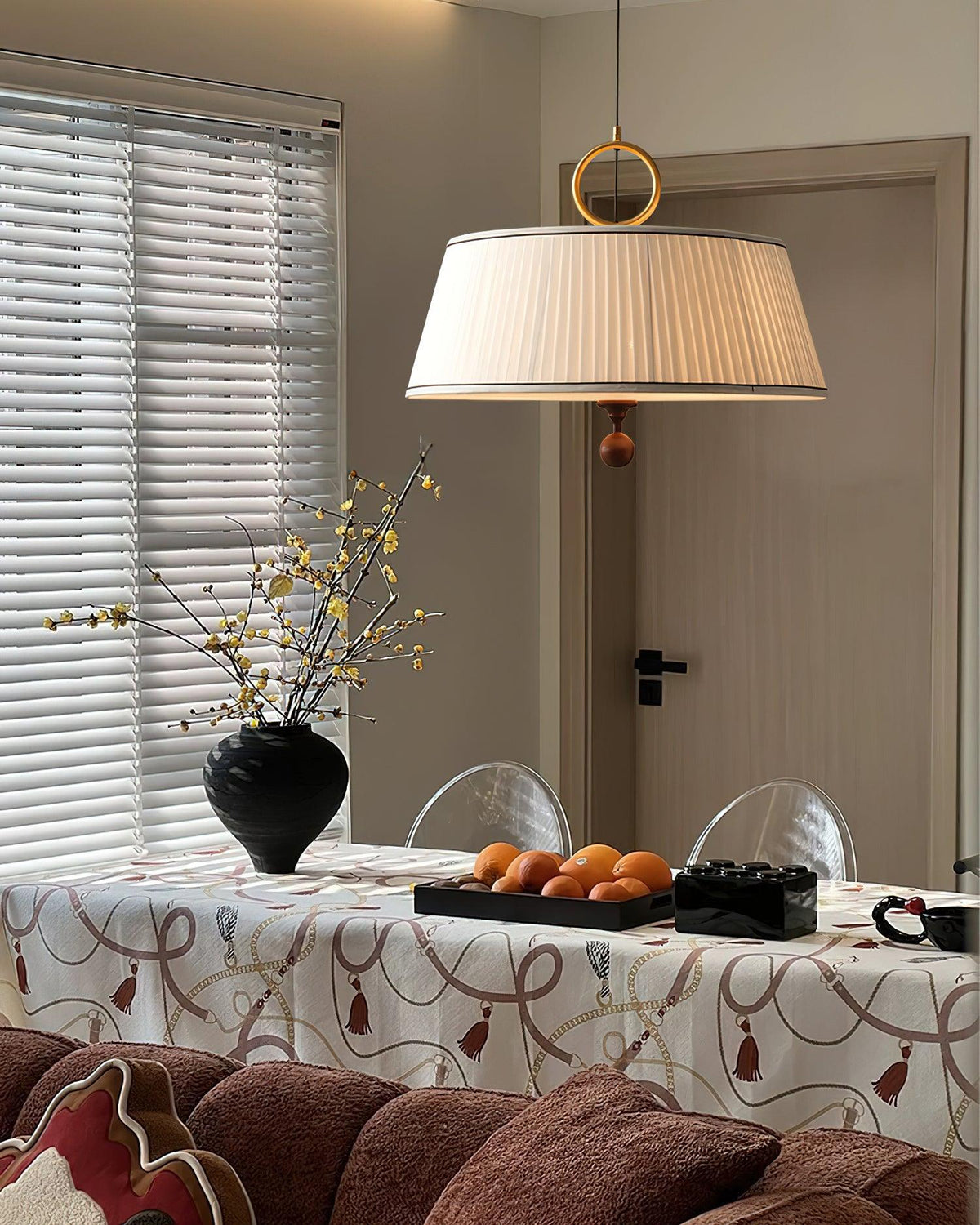 Lámpara colgante con pantalla plisada Jovela sobre una mesa de comedor – imagen 17